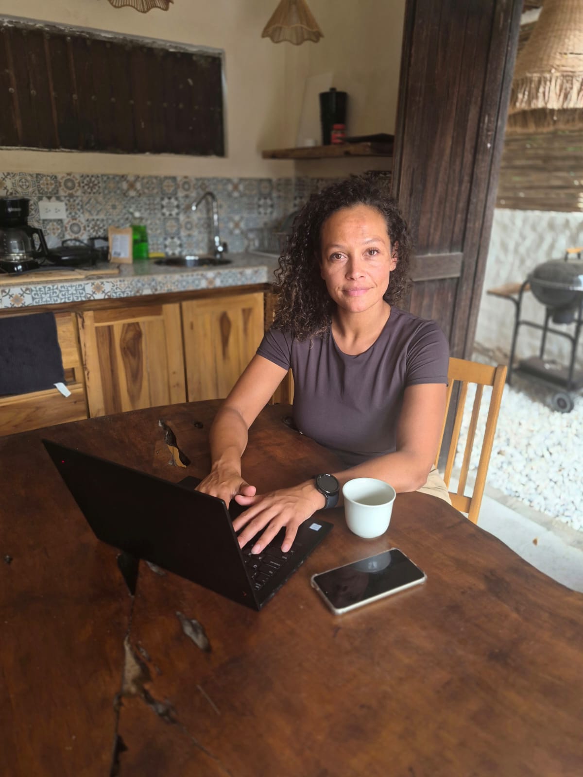 Afra, KIWA-certified counsellor & coach, at home with her laptop